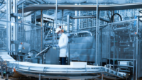 technologist looking at screen for equipment in dairy factory